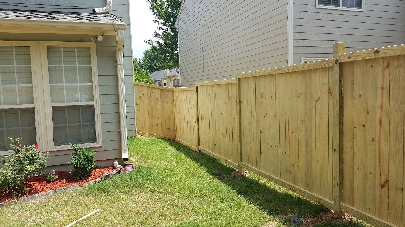 Residential backyard wooden privacy fence landscaping